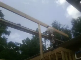 Carpenter setting a ridge beam over a new addition frame — Ice Dam Removal by Roofing Brothers in West Salisbury