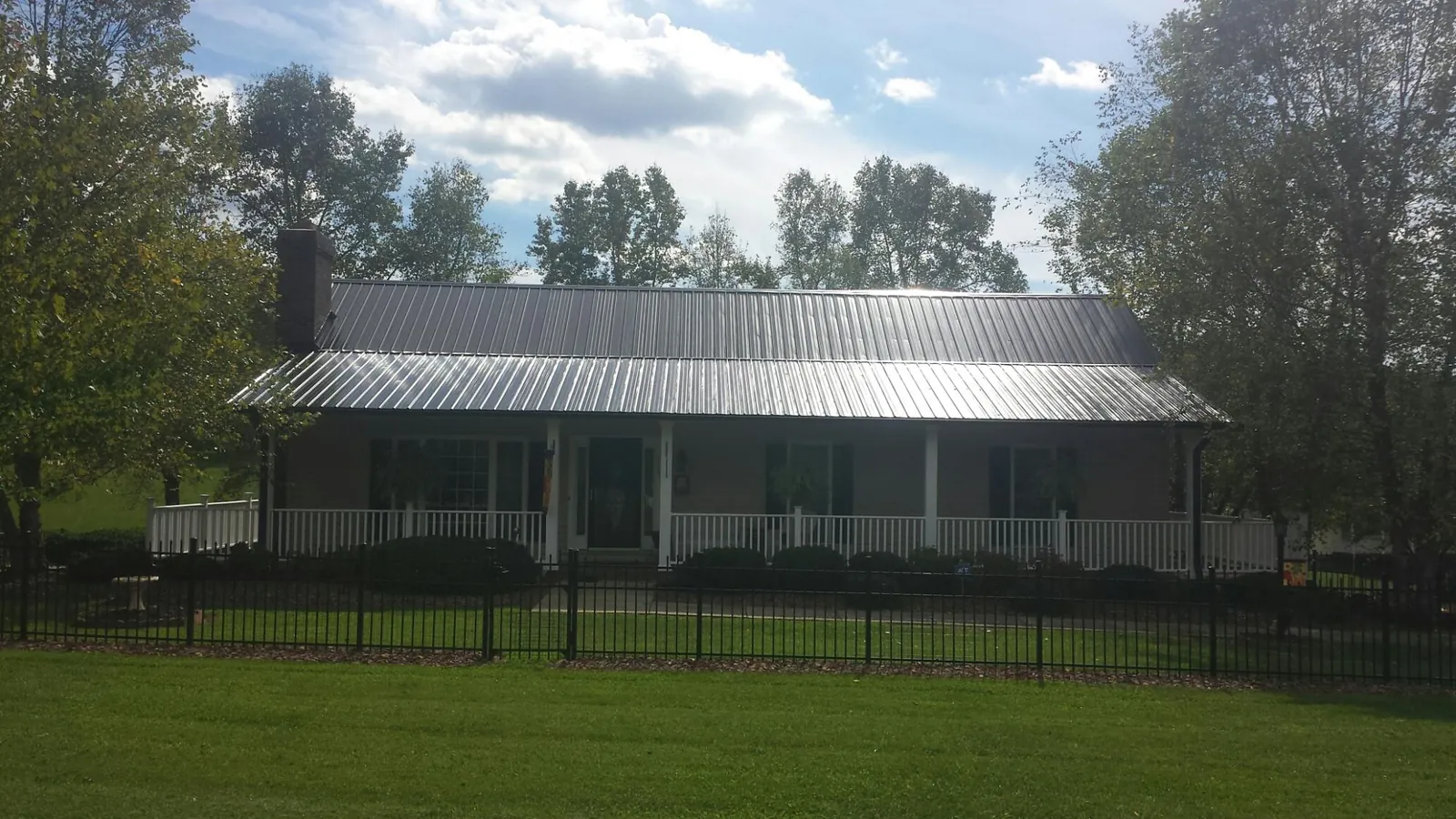 Gray metal roof on a brick ranch with a full width front porch — Gutter Guard Installation work by our crew in West Salisbury